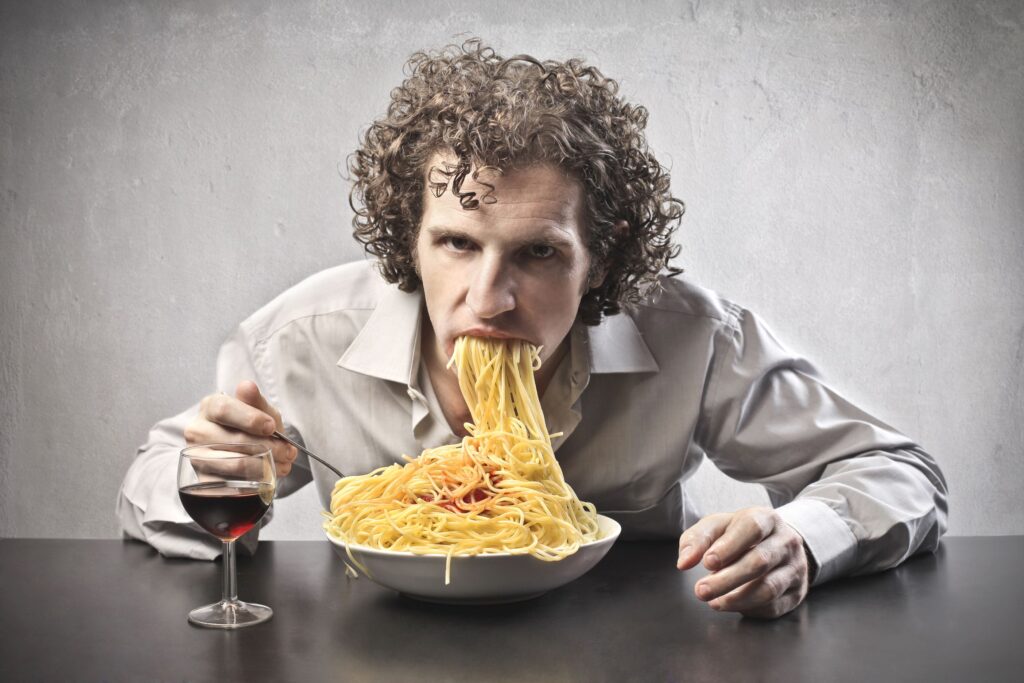 a man eating messy pasta